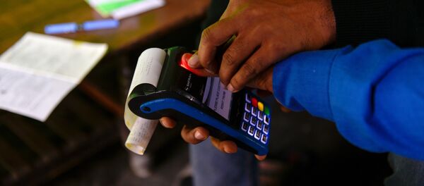 In this photograph taken on November 16, 2016, bank correspondent Mohammad Imran helps a villager to take his thumb print on a mobile banking machine in Basendua village in Bulandshahr, in northern Uttar Pradesh state In this photograph taken on November 16, 2016, bank correspondent Mohammad Imran helps a villager to take his thumb print on a mobile banking machine in Basendua village in Bulandshahr, in northern Uttar Pradesh state - Sputnik International