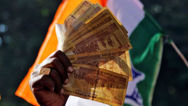 A man displays 500 Indian rupee notes during a rally organised by India’s main opposition Congress party against the government's decision to withdraw 500 and 1000 Indian rupee banknotes from circulation, in Ajmer, India, 24 November 2016. - Sputnik International