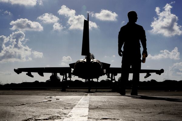 This photo taken on September 22, 2016 shows a British soldier walking by a Eurofighter Typhoon fighter jet at Royal Air Force's Akrotiri base in Cyprus, before taking off for a coalition mission over Iraq.  - Sputnik International