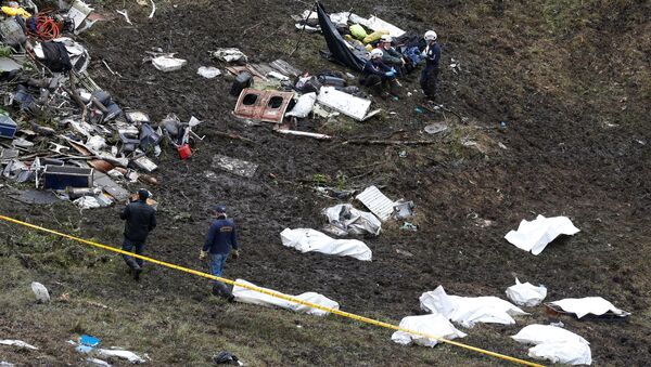Rescue workers walk next to bodies from the wreckage of a plane that crashed into the Colombian jungle with the Brazilian soccer team Chapecoense onboard near Medellin, Colombia - Sputnik International