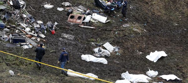 Rescue workers walk next to bodies from the wreckage of a plane that crashed into the Colombian jungle with the Brazilian soccer team Chapecoense onboard near Medellin, Colombia Rescue workers walk next to bodies from the wreckage of a plane that crashed into the Colombian jungle with the Brazilian soccer team Chapecoense onboard near Medellin, Colombia - Sputnik International