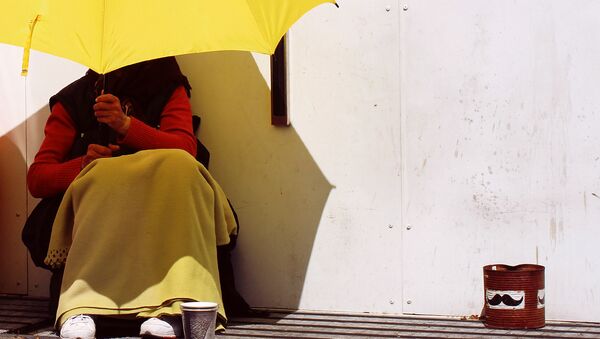 A beggar shields herself from the sun using a bright yellow umbrella, Malmo, Sweden - Sputnik International