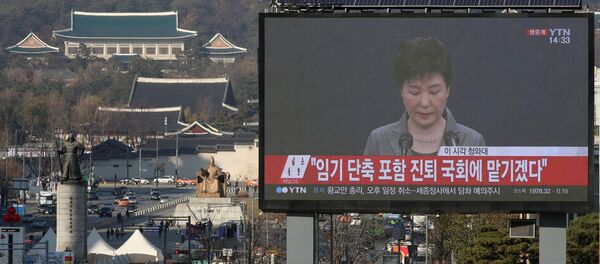 A large electronic board broadcasts a news report on South Korean President Park Geun-hye releasing a statement to the public as the Presidential Blue House (top L) is seen in the background, in central Seoul, South Korea, November 29, 2016. - Sputnik International