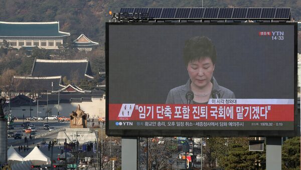 A large electronic board broadcasts a news report on South Korean President Park Geun-hye releasing a statement to the public as the Presidential Blue House (top L) is seen in the background, in central Seoul, South Korea, November 29, 2016. - Sputnik International