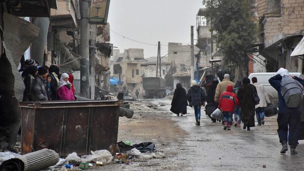 Syrian residents fleeing the eastern part of Aleppo walk through a street in Masaken Hanano, a former rebel-held district which was retaken by the regime forces last week. (File) - Sputnik International
