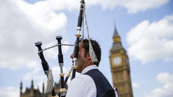 A Scottish piper plays for tourists in front of the Queen Elizabeth Tower (Big Ben) and The Houses of Parliament in central London on June 26, 2016. - Sputnik International