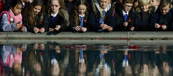 School children throw poppies into a fountain during an Armistice Day event at Trafalgar Square in London, Britain November 11, 2016. School children throw poppies into a fountain during an Armistice Day event at Trafalgar Square in London, Britain November 11, 2016. - Sputnik International