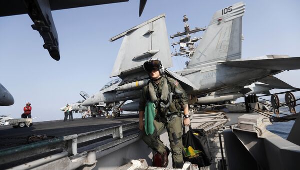 In this Tuesday, Nov. 22, 2016 photo, Lt. Jennifer Sandifer, a 27-year old fighter pilot from Austin, Texas, walks towards F/A-18E Super Hornet jet before launching from the deck of the U.S.S. Dwight D. Eisenhower aircraft carrier towards targets in Iraq and Syria - Sputnik International