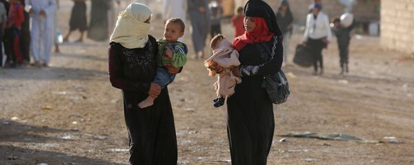 Iraqi refugees, who fled due to the ongoing conflict between pro-government forces and Islamic State (IS) group jihadists, walk at a camp in the northeastern town of al-Hol in Syria's Hasakeh province on October 19, 2016 Iraqi refugees, who fled due to the ongoing conflict between pro-government forces and Islamic State (IS) group jihadists, walk at a camp in the northeastern town of al-Hol in Syria's Hasakeh province on October 19, 2016 - Sputnik International
