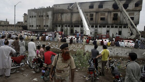 People gather at the site of burnt garment factory in Karachi, Pakistan on Wednesday, Sept. 12, 2012 - Sputnik International