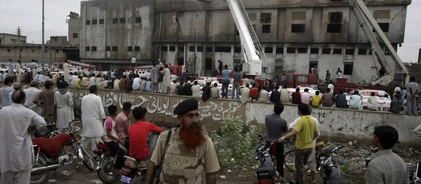 People gather at the site of burnt garment factory in Karachi, Pakistan on Wednesday, Sept. 12, 2012 People gather at the site of burnt garment factory in Karachi, Pakistan on Wednesday, Sept. 12, 2012 - Sputnik International