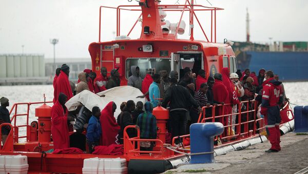 Migrants, who were part of a group intercepted aboard a dinghy off the coast in the Mediterranean sea, stand on a rescue boat upon arriving at a port in Malaga, southern Spain, December 3, 2016 - Sputnik International