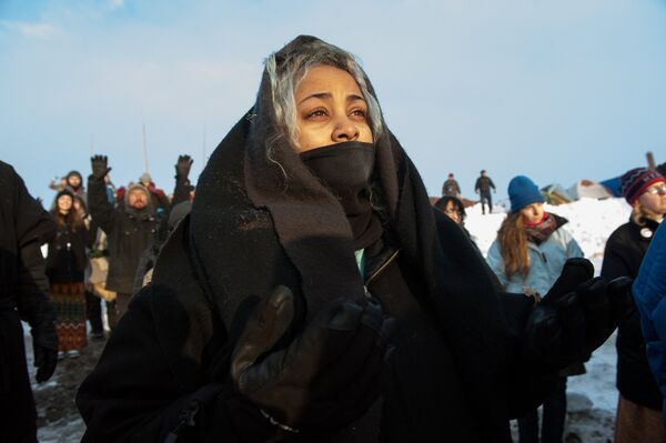 A woman watches the sunrise in Oceti Sakowin camp as water protectors continue to demonstrate against plans to pass the Dakota Access pipeline near the Standing Rock Indian Reservation, near Cannon Ball, North Dakota, U.S. December 3, 2016 A woman watches the sunrise in Oceti Sakowin camp as water protectors continue to demonstrate against plans to pass the Dakota Access pipeline near the Standing Rock Indian Reservation, near Cannon Ball, North Dakota, U.S. December 3, 2016 - Sputnik International