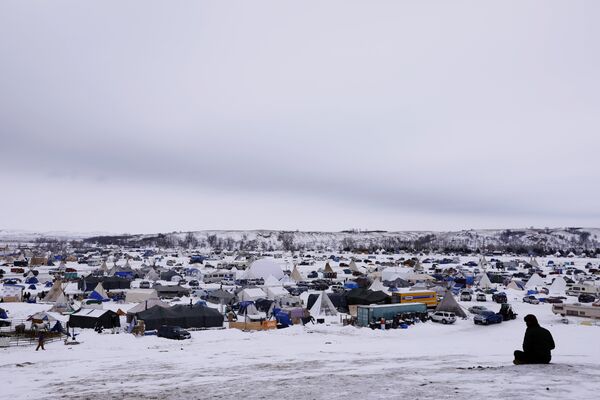 A man rests on top of a hill inside of the Oceti Sakowin camp as water protectors continue to demonstrate against plans to pass the Dakota Access pipeline near the Standing Rock Indian Reservation, near Cannon Ball, North Dakota, U.S., December 2, 2016 A man rests on top of a hill inside of the Oceti Sakowin camp as water protectors continue to demonstrate against plans to pass the Dakota Access pipeline near the Standing Rock Indian Reservation, near Cannon Ball, North Dakota, U.S., December 2, 2016 - Sputnik International