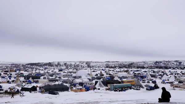 A man rests on top of a hill inside of the Oceti Sakowin camp as water protectors continue to demonstrate against plans to pass the Dakota Access pipeline near the Standing Rock Indian Reservation, near Cannon Ball, North Dakota, U.S., December 2, 2016 - Sputnik International