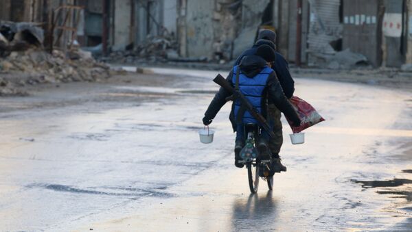 A rebel fighter carries food while riding a bicycle and carrying his weapon on his back in rebel-held besieged old Aleppo, Syria December 2, 2016 - Sputnik International
