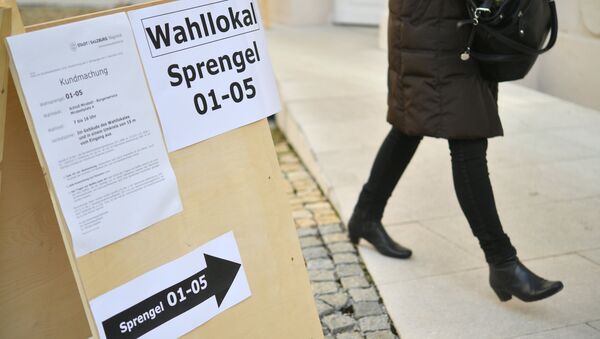 A woman past a sign showing the way to a polling station during the presidential election in Salzburg, Austria on December 4, 2016 - Sputnik International