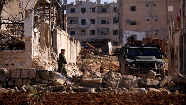 A Russian soldier walks to a military vehicle in goverment controlled Hanono housing district in Aleppo, Syria December 4, 2016 - Sputnik International