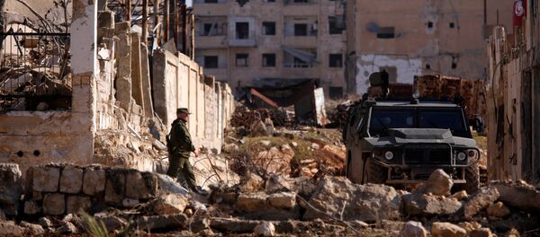 A Russian soldier walks to a military vehicle in goverment controlled Hanono housing district in Aleppo, Syria December 4, 2016 - Sputnik International