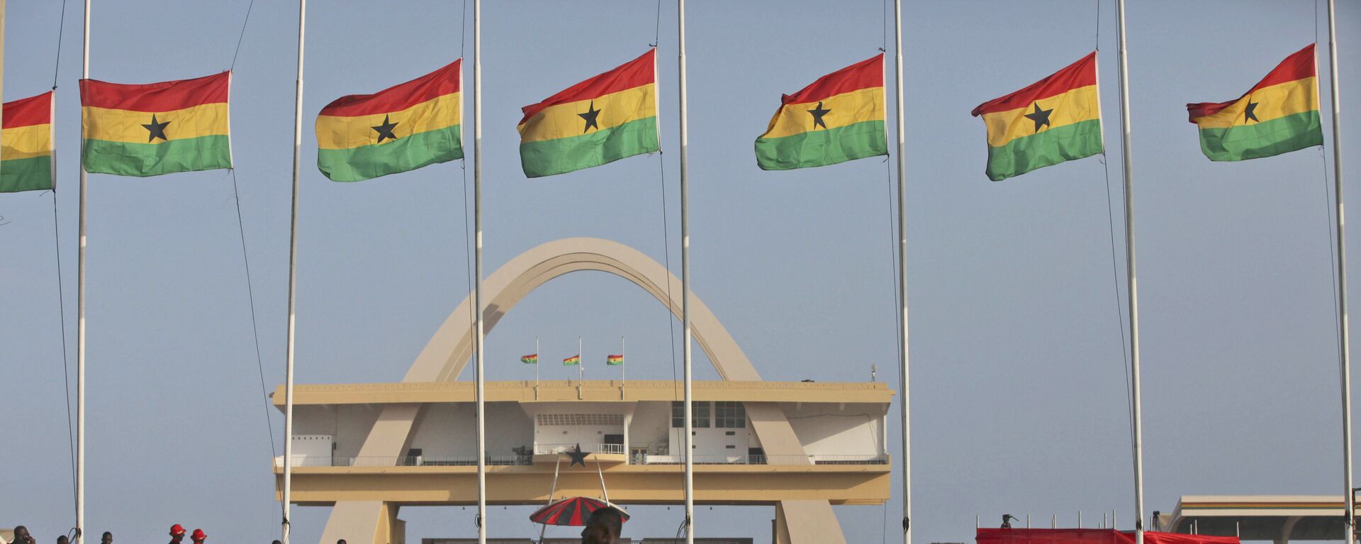 A man rides a bicycle past Ghanian flags flown at half mast to honor late Ghanian President, John Evans Atta Mills at the independence square in Accra, Ghana, Thursday, Aug.9, 2012.  - Sputnik International, 1920, 25.11.2021