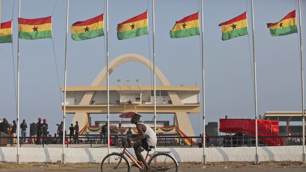 A man rides a bicycle past Ghanian flags flown at half mast to honor late Ghanian President, John Evans Atta Mills at the independence square in Accra, Ghana, Thursday, Aug.9, 2012. - Sputnik International