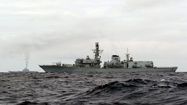 This is a handout photo issued by Britain's Ministry of Defence taken on Wednesday Oct. 19, 2016, of HMS Richmond, foreground, a Type 23 Duke Class frigate, observing aircraft carrier Admiral Kuznetsov, at rear left, which is part of a Russian task group, during transit through the North Sea - Sputnik International