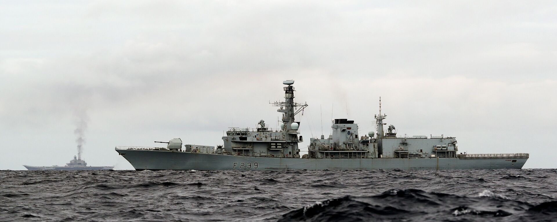 This is a handout photo issued by Britain's Ministry of Defence taken on Wednesday Oct. 19, 2016, of HMS Richmond, foreground, a Type 23 Duke Class frigate, observing aircraft carrier Admiral Kuznetsov, at rear left, which is part of a Russian task group, during transit through the North Sea - Sputnik International, 1920, 27.09.2021