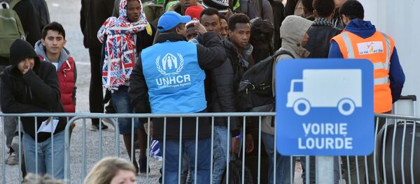Volonteers of the United Nations High Commissioner for Refugees (UNHCR) agency and La Vie Active association help unaccompanied migrant minors, from the demolished Jungle migrant camp in Calais, to board a bus to travel to reception centres around France on November 2, 2016 in Calais, northern France - Sputnik International