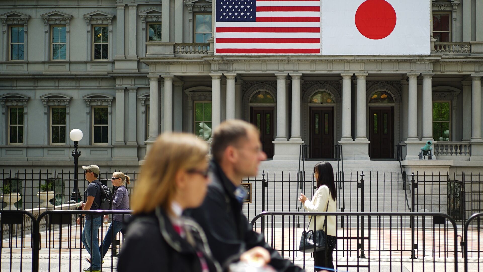 Pedestrians pass infront of US and Japan flags on the Eisenhower Executive Office Building next to the White House on April 27, 2015 in Washington, DC - Sputnik International, 1920, 07.02.2022