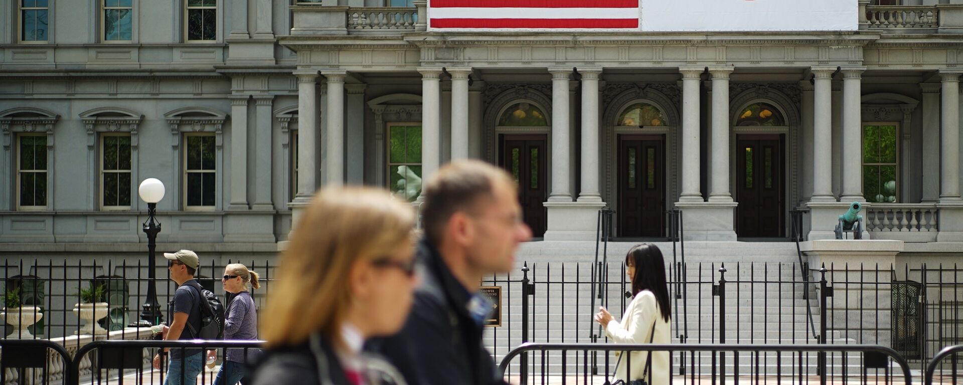 Pedestrians pass infront of US and Japan flags on the Eisenhower Executive Office Building next to the White House on April 27, 2015 in Washington, DC - Sputnik International, 1920, 07.02.2022