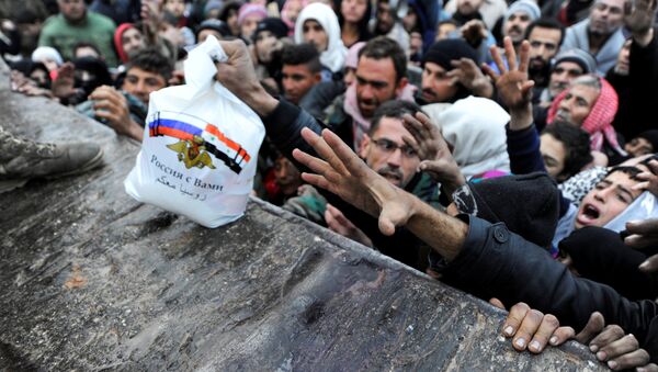 Syrians who have been evacuated from eastern Aleppo, reach out for Russian food aid in government-controlled Jibreen area in Aleppo, Syria November 30, 2016. The text on the bag, which shows the Syrian and Russian national flags, reads in Arabic: Russia is with you. - Sputnik International