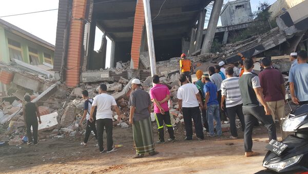 People survey the damage after dozens of buildings collapsed following a 6.4 magnitude earthquake in Ule Glee, Pidie Jaya in the northern province of Aceh, Indonesia December 7, 2016. - Sputnik International