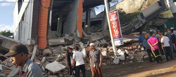 People survey the damage after dozens of buildings collapsed following a 6.4 magnitude earthquake in Ule Glee, Pidie Jaya in the northern province of Aceh, Indonesia December 7, 2016. - Sputnik International