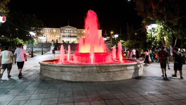 People walk near the fountain at Syntagma Square in front of the Greek Parliament in central Athens on July 4, 2015. - Sputnik International