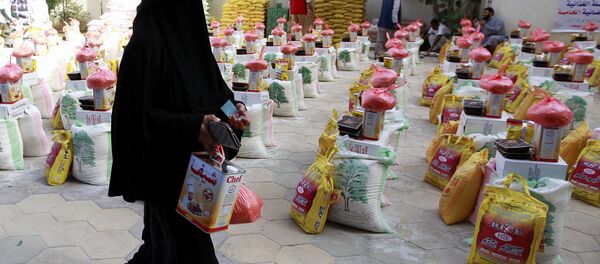 A Yemeni woman affected by the country's ongoing conflict walks past food rations provided by an initiative organised by a local charity in the capital Sanaa on June 2, 2016. - Sputnik International