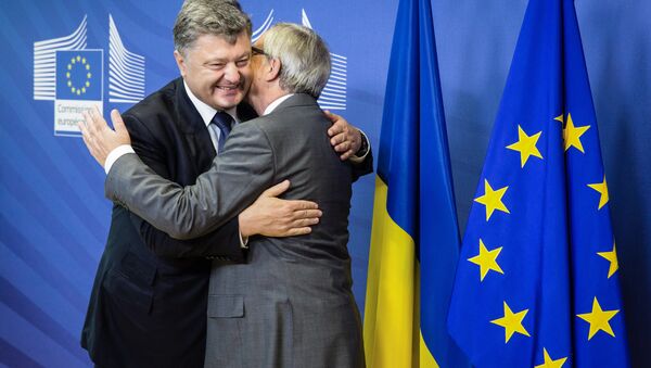 This handout picture taken and released by the Ukrainian presidential press-service shows President of the European Commission Jean-Claude Juncker (R) and Ukrainian President Petro Poroshenko embracing prior their talks in Brussels on August 27, 2015. - Sputnik International