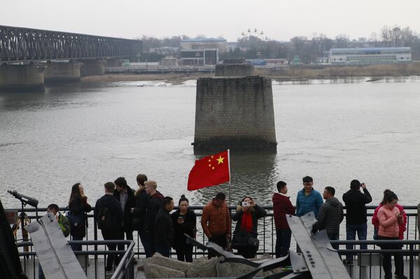 Tourists take pictures at the Dandong Broken Bridge Scenic Area in Dandong, Liaoning Province  - Sputnik International