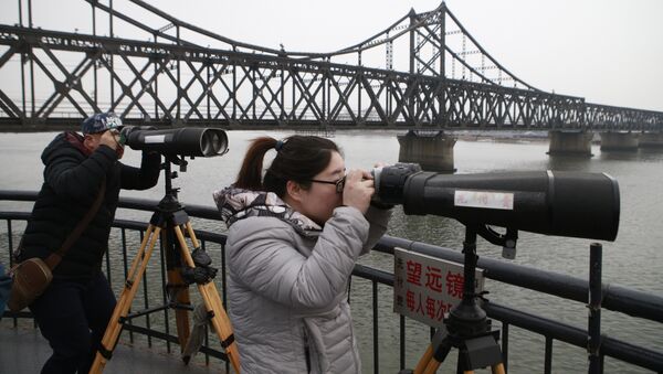 Chinese tourists watch the North Korean side across the Yalu River using telescopes in Dandong, Northeast China's Liaoning Province - Sputnik International