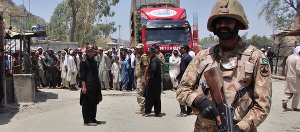 A Pakistani soldier stands guard as a truck enters Pakistan from Afghanistan at the border crossing in Torkham - Sputnik International