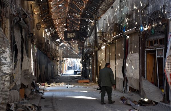 A Syrian Army soldier walks past closed shops in the Bab al-Nasr district of Aleppo's Old City on December 9, 2016 - Sputnik International