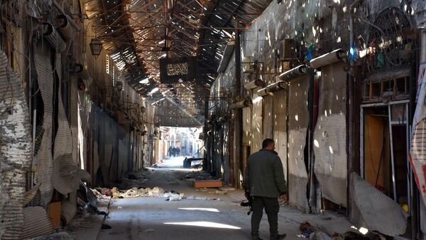 A Syrian Army soldier walks past closed shops in the Bab al-Nasr district of Aleppo's Old City on December 9, 2016 - Sputnik International