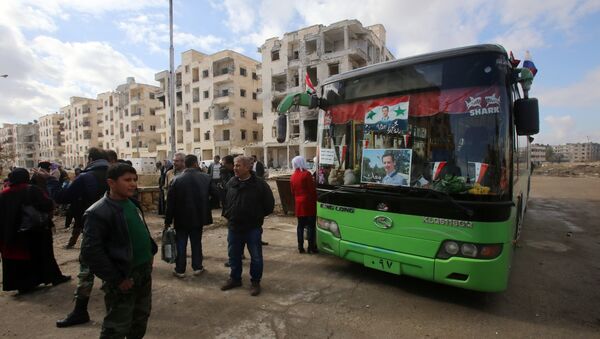 Syrians, from various western districts, wait at the Razi bus stop in Aleppo's central Jamiliyeh neighbourhood before taking part in a bus trip through government-held territory between the two sides of the divided city on December 3, 2016 as the pro-government forces seized 60 percent of the former rebel stronghold in east Aleppo - Sputnik International