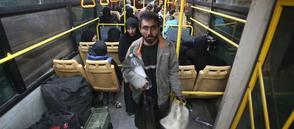 Syrian residents of the Old City of Aleppo stand in a bus at a crossing point during their evacuation to a distinct government-controlled area of the city early on December 7, 2016 Syrian residents of the Old City of Aleppo stand in a bus at a crossing point during their evacuation to a distinct government-controlled area of the city early on December 7, 2016 - Sputnik International