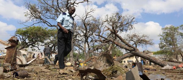 A security officer walks past a temporary stall destroyed after a suicide car bomb went off at the entrance of Somalia's biggest port in its capital Mogadishu December 11, 2016 - Sputnik International