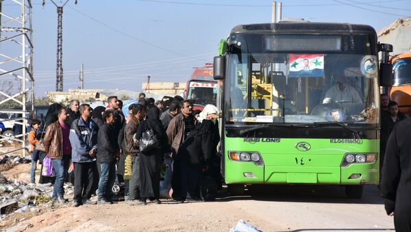 Syrian residents fleeing the violence, queue as they board a bus at a checkpoint, manned by pro-government forces, in the village of Aziza on the southwestern outskirts of the northern Syrian city of Aleppo on December 9, 2016 - Sputnik International