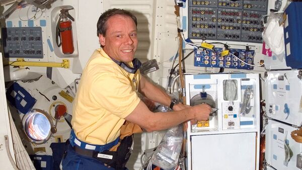 US space shuttle Discovery Mission Specialist European Space Agency (ESA) astronaut Christer Fuglesang of Sweden prepares food in the galley on the middeck of Discovery 11 December 2006 - Sputnik International