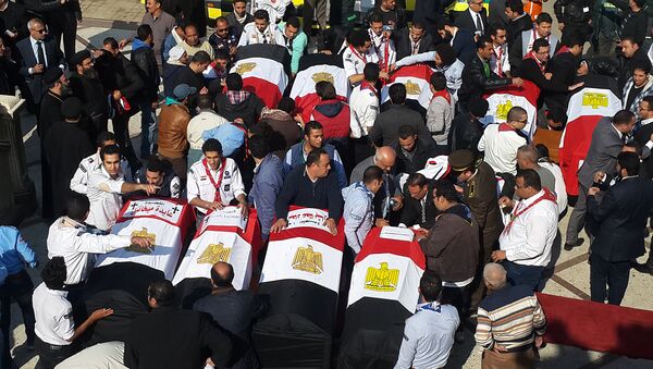 Egyptian mourners and officials stand next to the coffins of the victims of a bomb explosion that targeted a Coptic Orthodox Church the previous day in Cairo, at the end their funeral in the capital's Nasr City neighbourhood on December 12, 2016 - Sputnik International