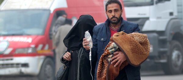 A man carries a child with an IV drip as he flees deeper into the remaining rebel-held areas of Aleppo, Syria December 12, 2016 - Sputnik International