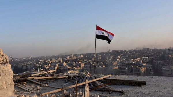 A Syrian national flag flutters near a general view of eastern Aleppo after Syrian government soldiers took control of al-Sakhour neigborhood in Aleppo, Syria in this handout picture provided by SANA on November 28, 2016. - Sputnik International