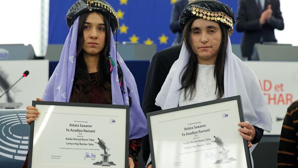Nadia Murad Basee Taha (L) and Lamiya Aji Bashar, both Iraqi women of the Yazidi faith, pose with the 2016 Sakharov Prize during an award ceremony at the European Parliament in Strasbourg, France, December 13, 2016 - Sputnik International